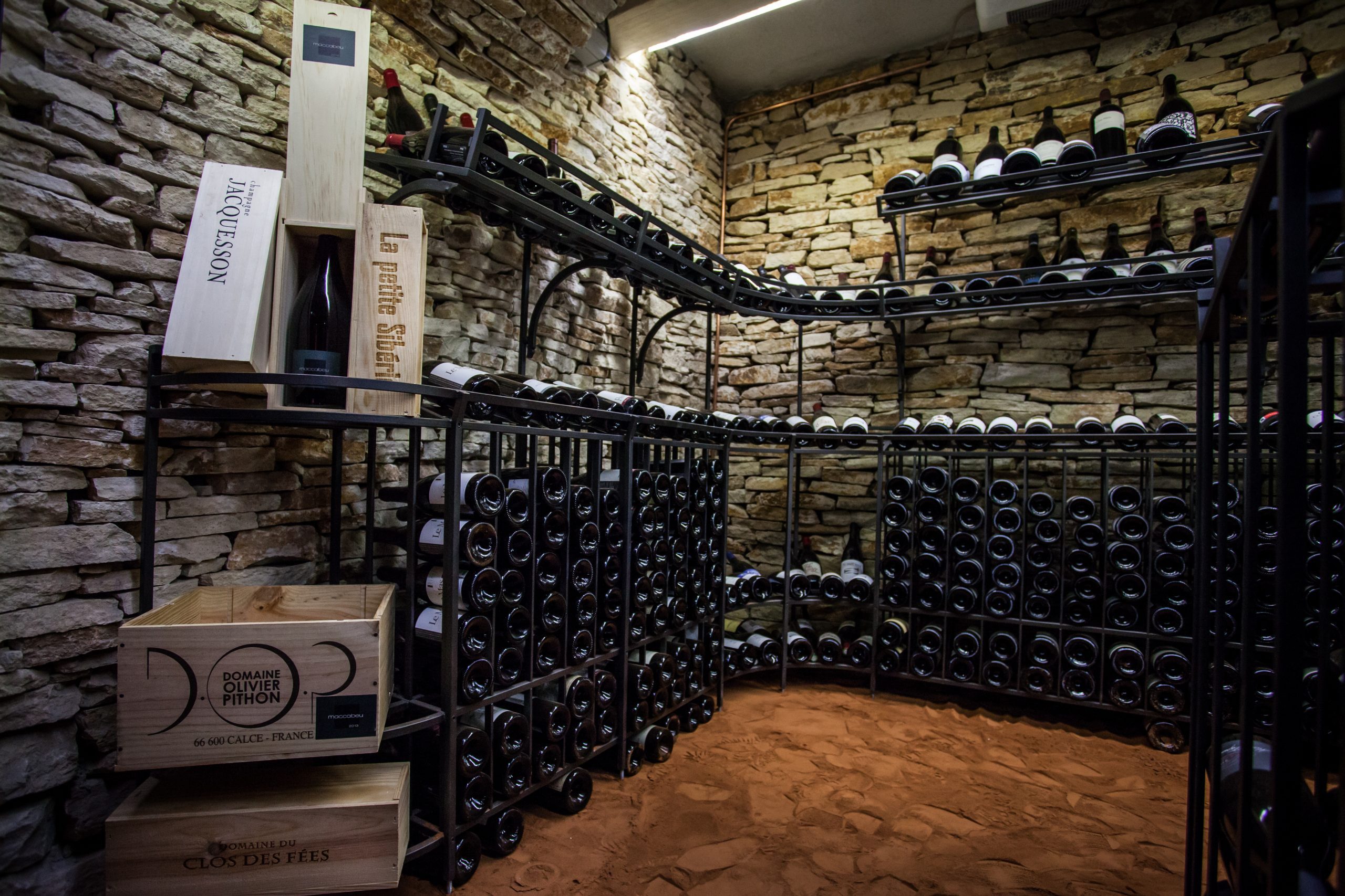 La cave à vin en pierre avec les bouteilles de vins